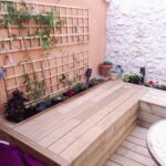 la maison de nous, aménagement extérieur, terrasse bois, mur pierres apparentes, enduit ton brique, jardinière, plants et fleurs d'ornements